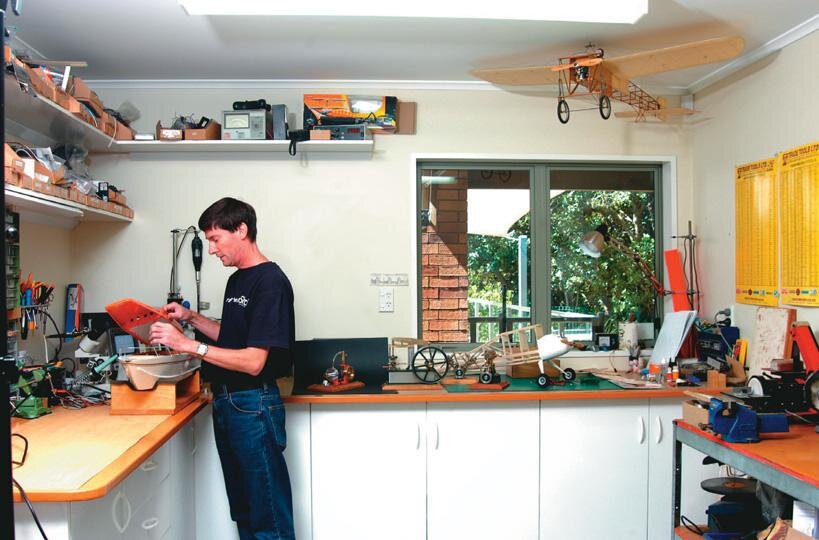 Ross Purdy with model engines and  boat  in his shed