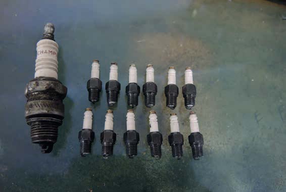 The completed plugs alongside a short-reach champion spark plug
