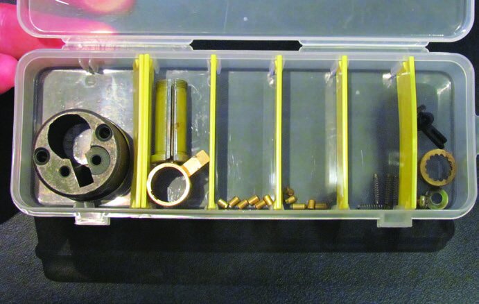 The broken down insides of a pin tumbler lock, showing, from left to right, the hull, the plug, the key pins, the driver pins, the springs and other sundry pieces.