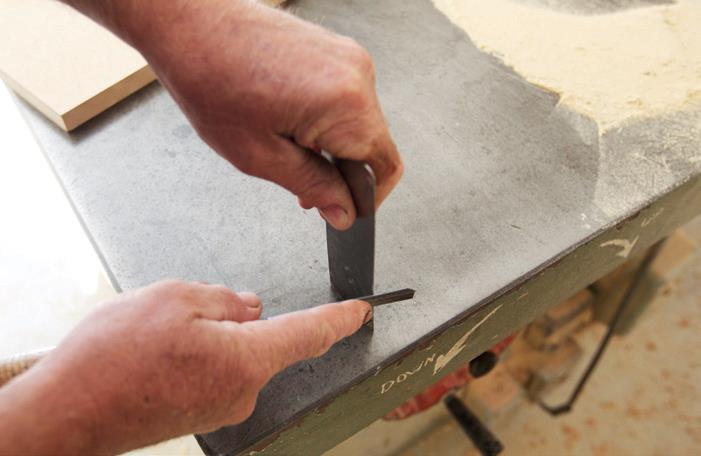 Neil sharpening the scraper with an old chisel.