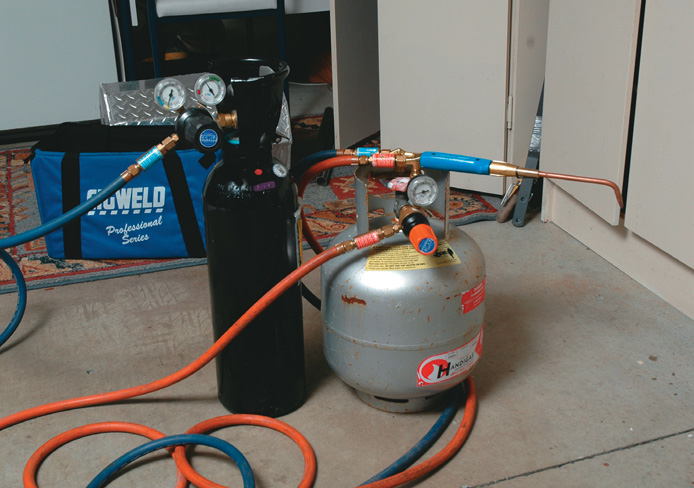 Black oxygen and silver LPG tank. Nte orange hose for LPG