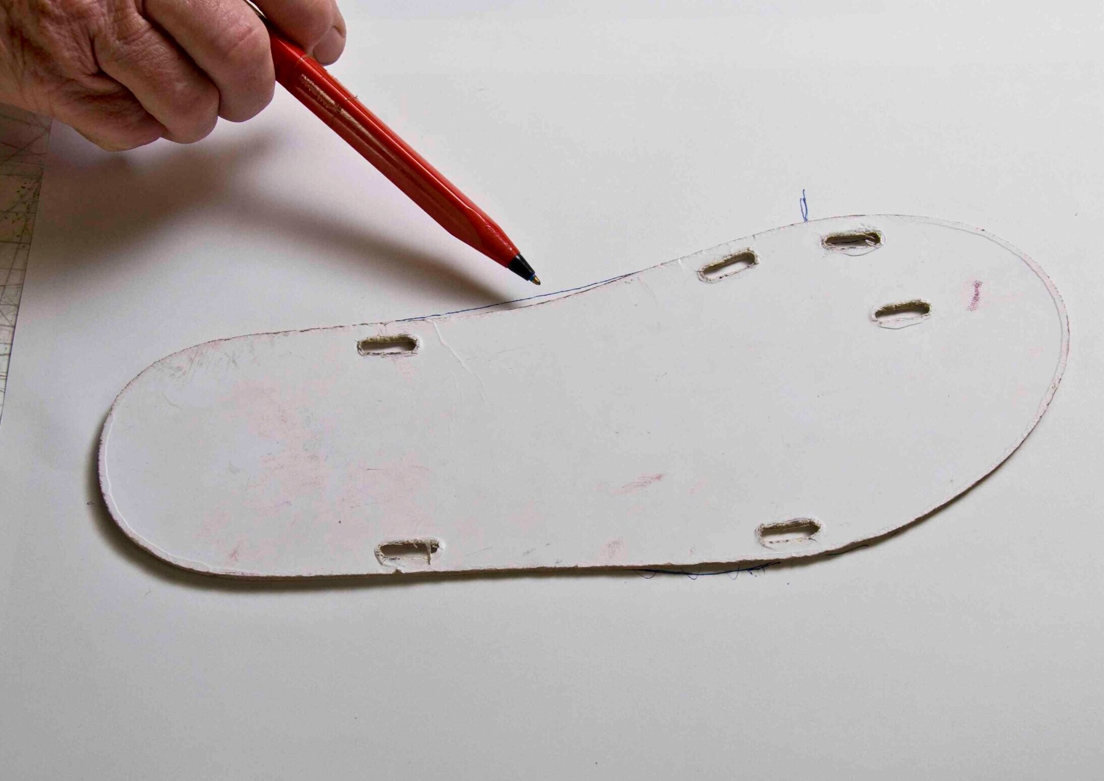 Refining the shape of the sole. You could make a cardboard template either freehand or by tracing an existing sole.