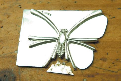 Pieces are soldered onto a silver sheet.