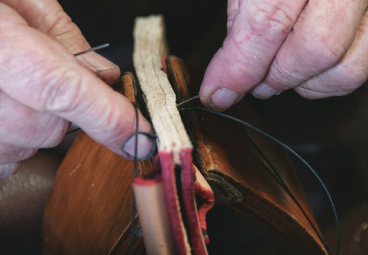 Using two needles to stitch sheath pieces and spacer held in saddler’s vice. 