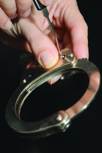 Using a single tool to open a ratchet- system handcuff