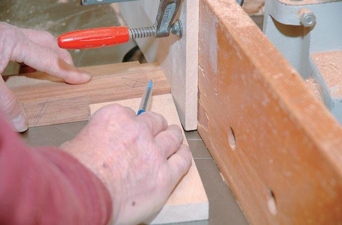 Cutting the side rail tenon shoulders. Note the fence used to maintain the angle of the rail