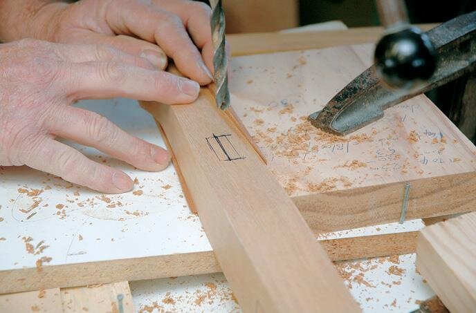 Cutting the mortise for the lower stretchers. Bandsawn off-cuts level the leg