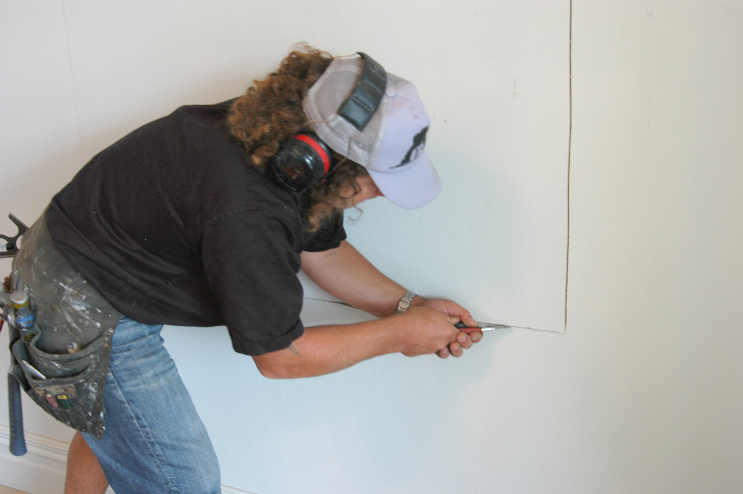 Use a Stanley, or a builder knife to cut plasterboard
